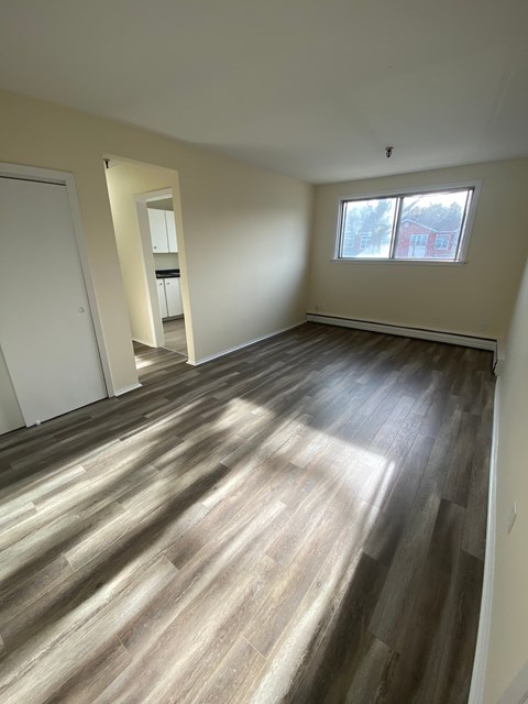 A room with wooden flooring and a window.