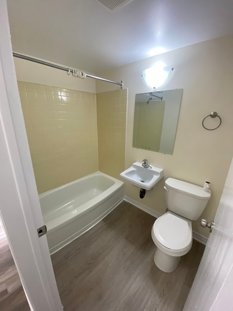 A white toilet sits next to a white sink in a bathroom.