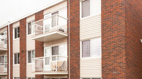 A red brick building with a balcony.