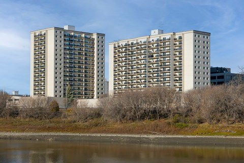 Two identical buildings are situated next to a body of water.