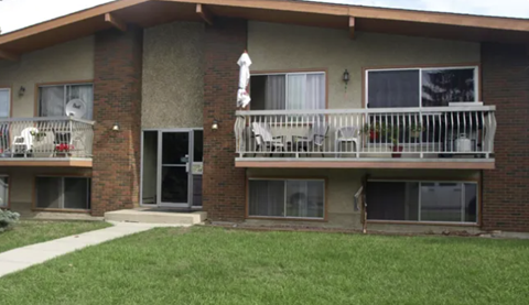 A two-story apartment building with a balcony on the second floor.