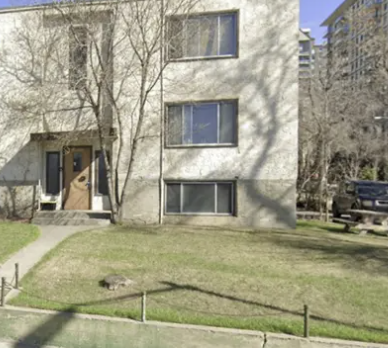 A concrete building with a brown door and windows.