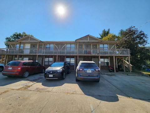 Two cars are parked in front of a house.