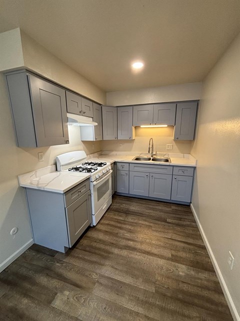 A kitchen with a white counter top and a white stove top oven.