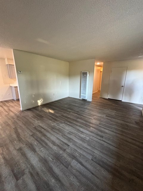 A room with wooden flooring and white walls.