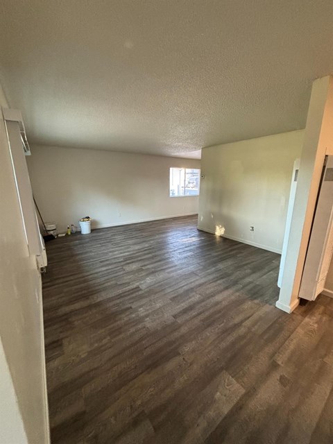 A room with wooden flooring and white walls.