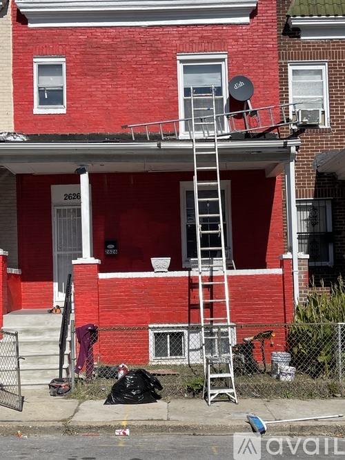 A red brick house with a ladder on the front porch.