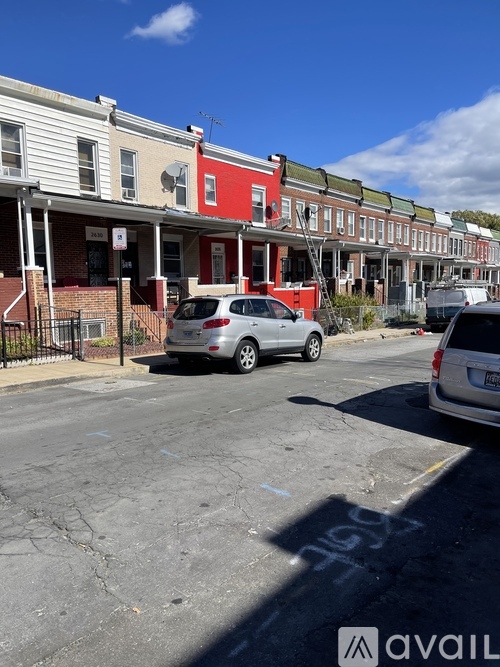 A row of houses with cars parked in front.