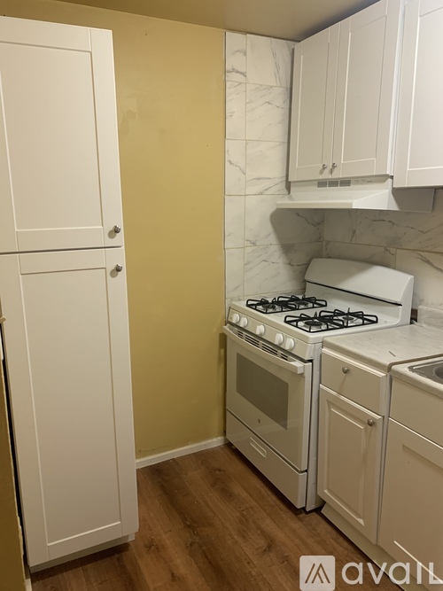 A kitchen with a white stove and cabinets.