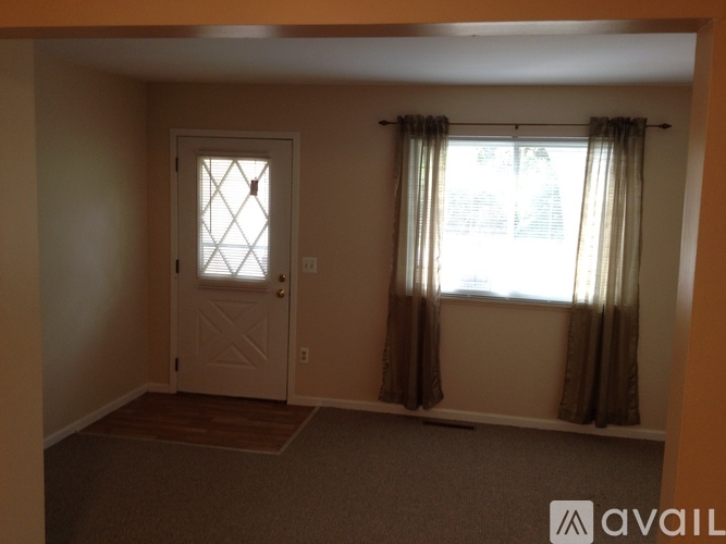 A room with a door and a window with curtains.