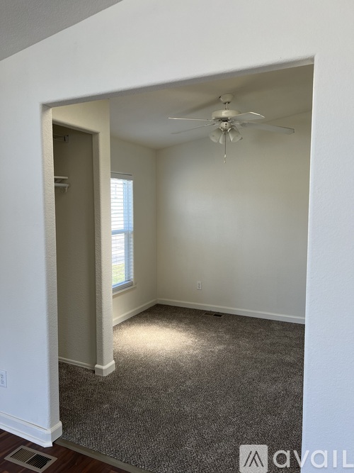 A room with a ceiling fan and a window.