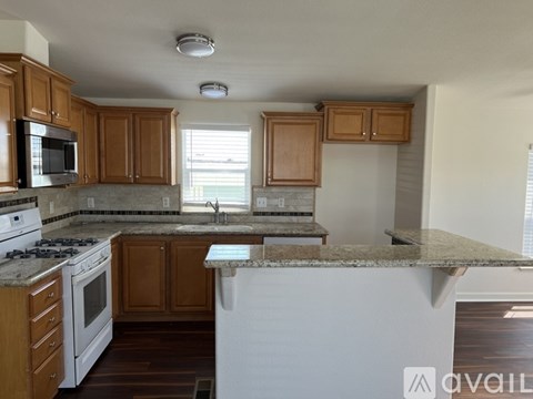 A kitchen with wooden cabinets and a white stove top oven.