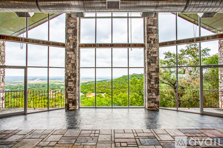 A large room with a glass wall and a stone pillar.