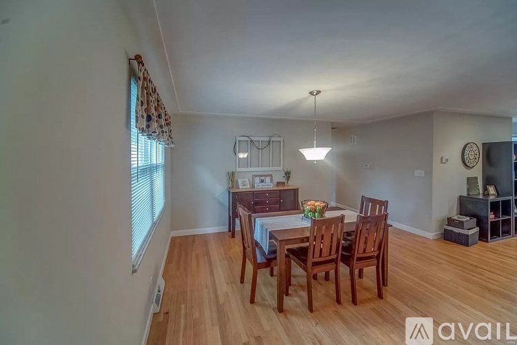 A dining room with a wooden table and chairs.