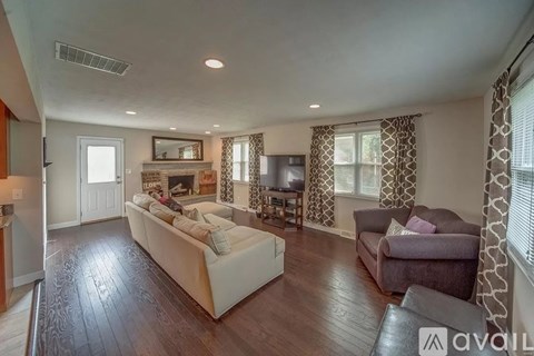 A living room with a white couch and a television.