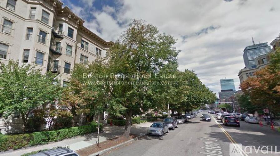 A street view of a residential area with cars parked on the side of the road.