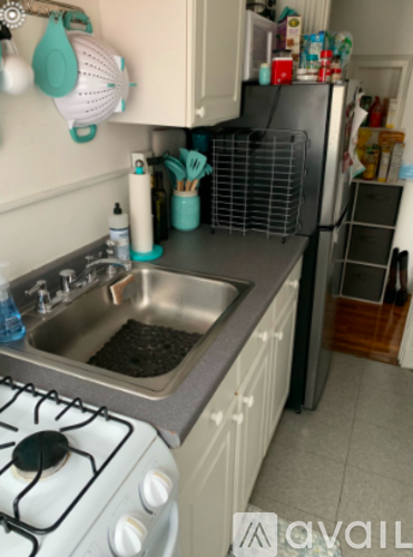 A kitchen with a white stove top and a silver sink.