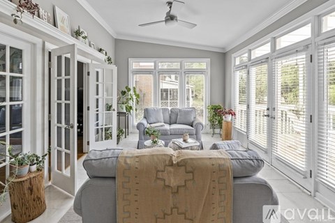 A well-lit, spacious bedroom with a large bed and a ceiling fan.