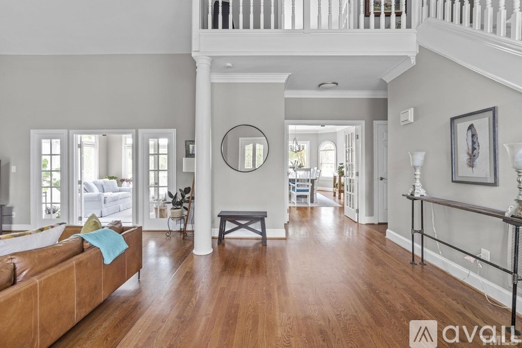 A living room with a tan couch and a wooden floor.
