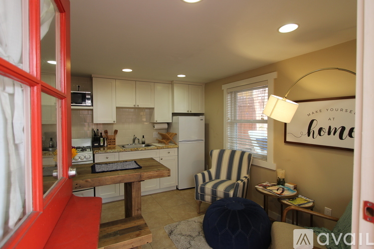 A kitchen with a red fridge and a striped chair.