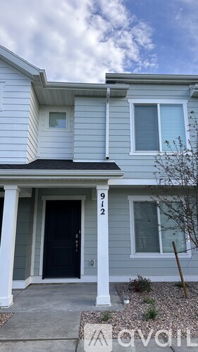 A two-story house with a black front door and white trim.