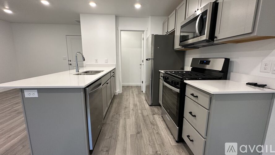 A kitchen with a white counter top and stainless steel appliances.