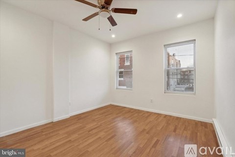 A room with wooden flooring and a ceiling fan.