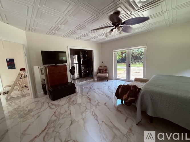 A bedroom with a marble floor and a ceiling fan.