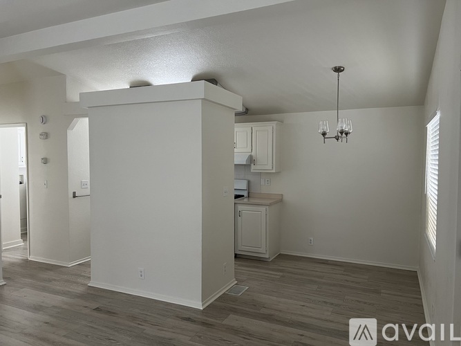 A well-lit, spacious room with a cabinet and a chandelier.