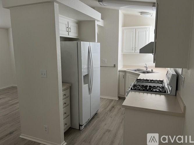 A kitchen with a refrigerator, stove, and sink.