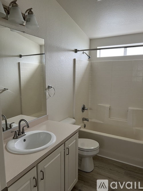 A bathroom with a white sink, toilet, and bathtub.