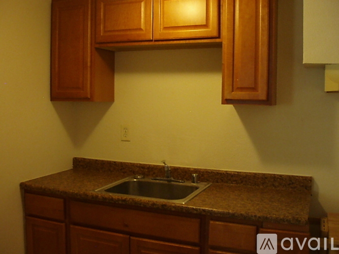 A kitchen with brown cabinets and a granite countertop.
