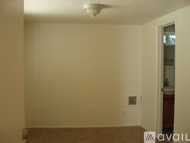 A room with a carpeted floor and a doorway leading to another room.