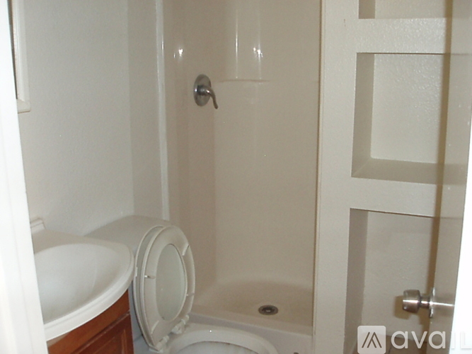 A white toilet sits next to a white sink in a small bathroom.