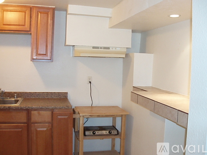 A kitchen with wooden cabinets and a white wall.