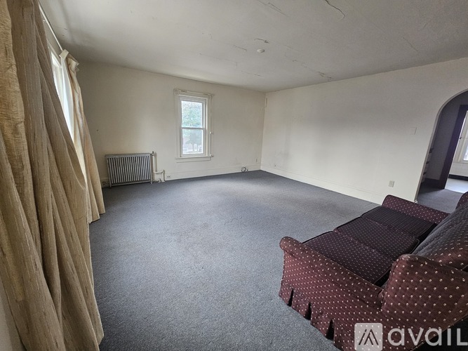 A living room with a couch and a window.