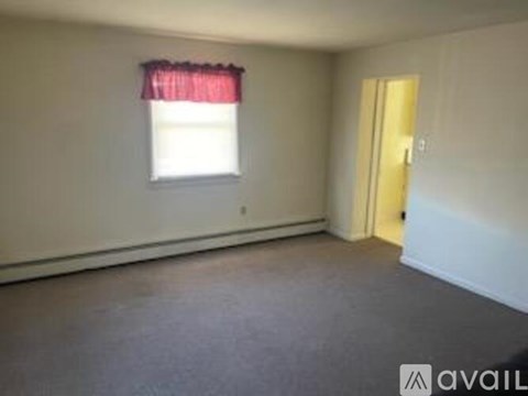 A room with a window and a door is available for rent.