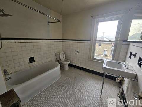A bathroom with a bathtub, toilet, and sink.
