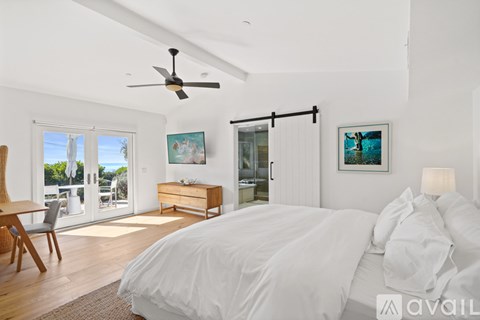 A bedroom with a large bed and a ceiling fan.