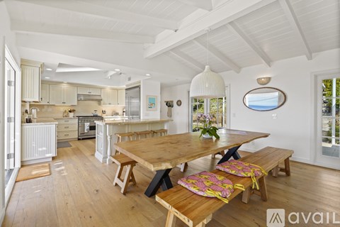 A wooden dining table with chairs and a bench in a spacious kitchen.