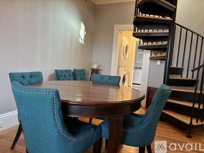 A dining room with a round table and six chairs.