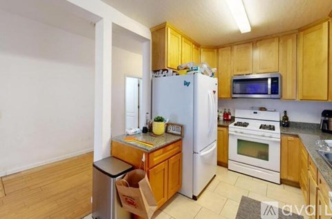 A kitchen with wooden cabinets and a white refrigerator.