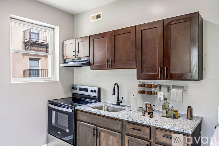 A kitchen with wooden cabinets and a black microwave oven.