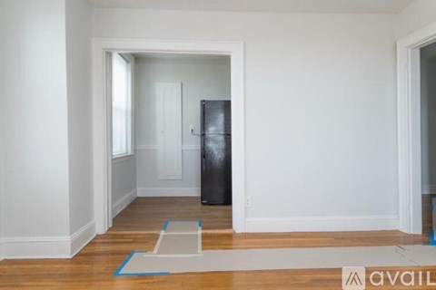 A room with a black fridge and a white door.