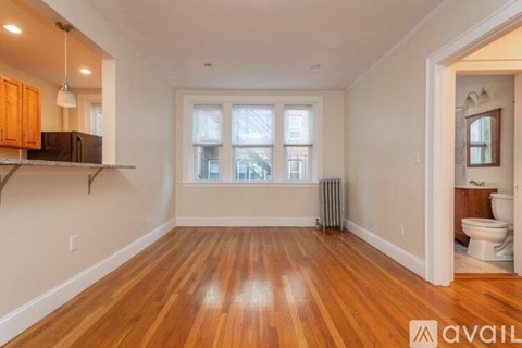 A room with wooden floors and a window overlooking a street.