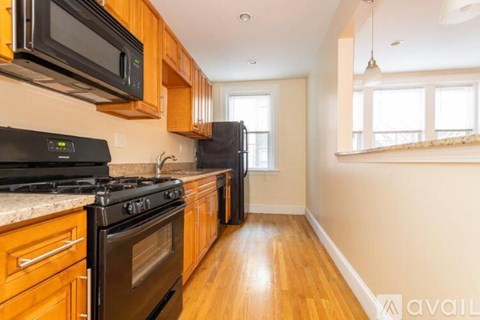 A kitchen with wooden cabinets and black appliances.