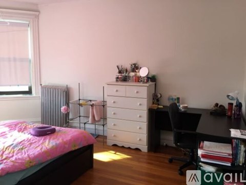 A bedroom with a bed, desk, and chair.