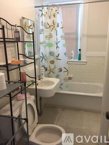 A bathroom with a toilet, sink, and shower curtain.