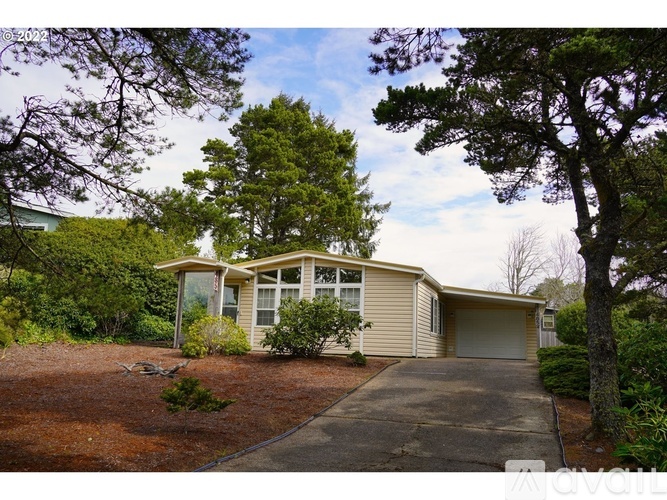 A house with a driveway and trees in the background.