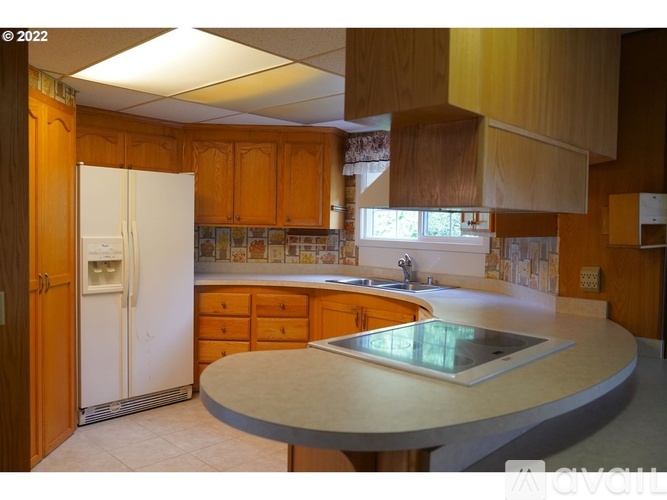 A kitchen with wooden cabinets and a white refrigerator.